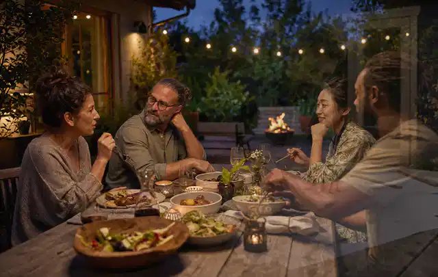 Menschen verbringen einen ruhigen Abend an einem Sitzplatz im Garten; Thema Aufstellpools, Schwerpunkt Reinigung; Umsetzung.