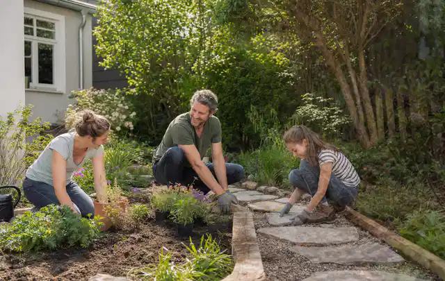 Familie geht auf einem Weg durch einen abwechslungsreich gestalteten Garten; Thema Balkon, Schwerpunkt Bepflanzung; Ergebnis.