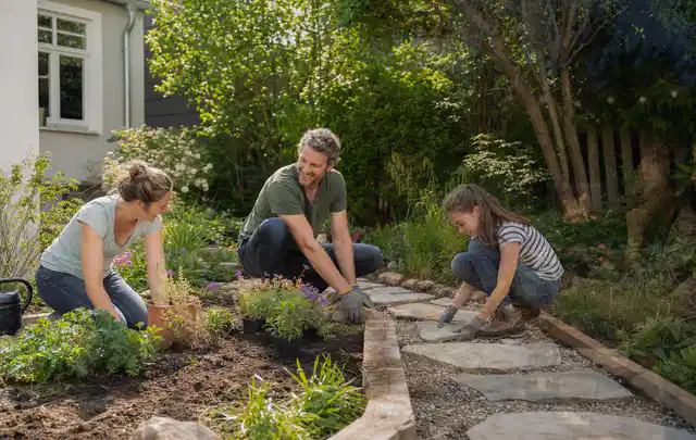 Familie geht auf einem Weg durch einen abwechslungsreich gestalteten Garten; Thema Bambus Sichtschutz, Schwerpunkt DIY; Kontrolle.