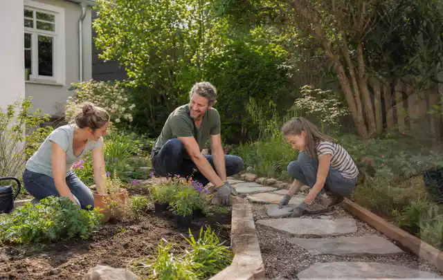 Familie geht auf einem Weg durch einen abwechslungsreich gestalteten Garten; Thema Bambus Sichtschutz, Schwerpunkt Gärten mit kleiner Fläche; Praxisalltag.