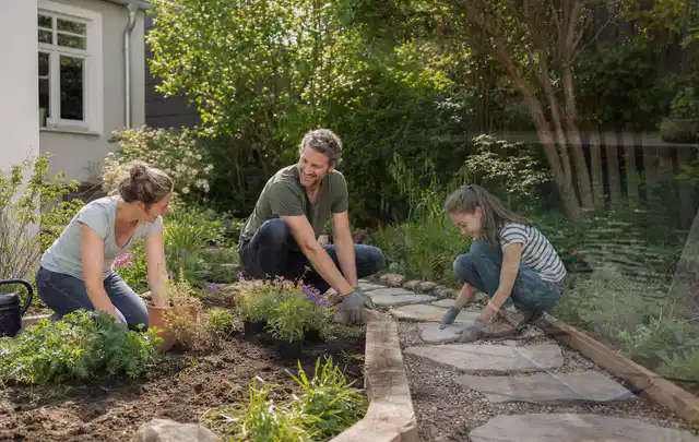 Familie geht auf einem Weg durch einen abwechslungsreich gestalteten Garten; Thema Bambus Sichtschutz, Schwerpunkt Gestaltung; Kontrolle.