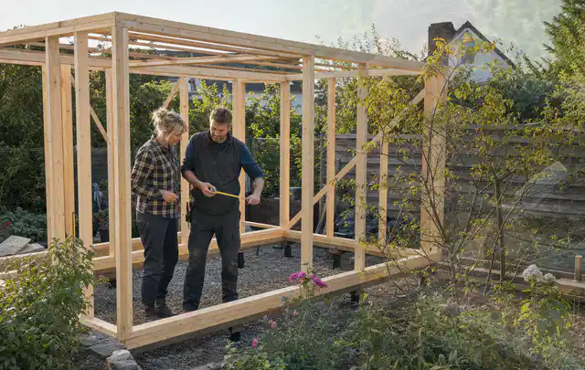 Person plant den Bau eines Gartenhauses auf einer vorbereiteten Fläche; Thema Carports, Schwerpunkt Aufbau; Ergebnis.