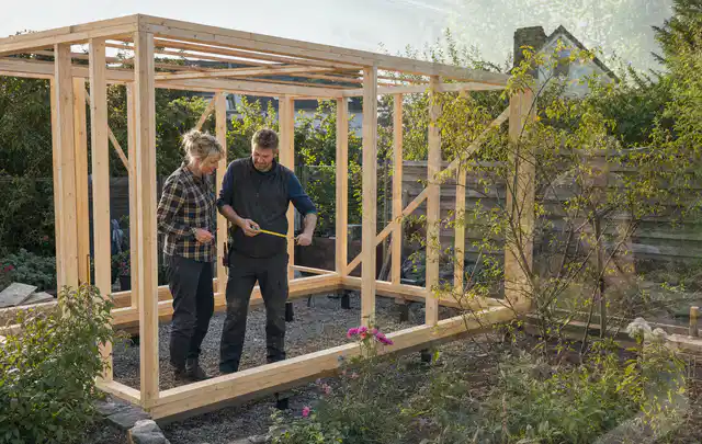 Person plant den Bau eines Gartenhauses auf einer vorbereiteten Fläche; Thema Carports, Schwerpunkt Fundament; Ausgangslage.