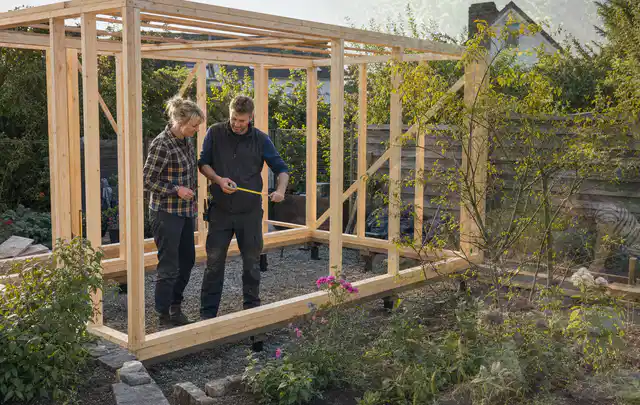 Person plant den Bau eines Gartenhauses auf einer vorbereiteten Fläche; Thema Carports, Schwerpunkt Materialwahl; Ergebnis.