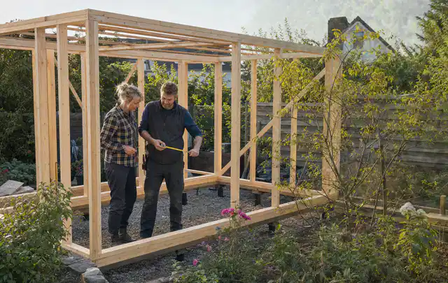 Person plant den Bau eines Gartenhauses auf einer vorbereiteten Fläche; Thema Carports, Schwerpunkt Nachhaltigkeit; Kontrolle.