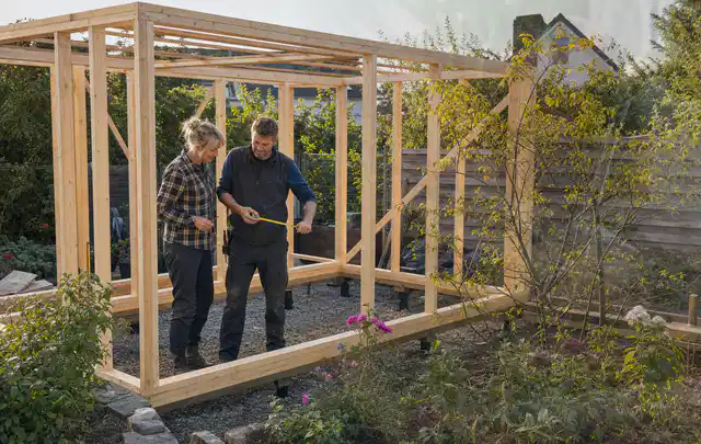 Person plant den Bau eines Gartenhauses auf einer vorbereiteten Fläche; Thema Carports, Schwerpunkt Pflege; Praxisalltag.