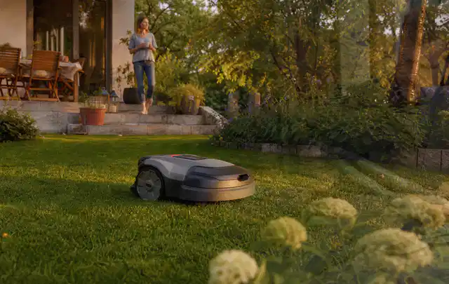 Mähroboter fährt am Abend über einen Rasen im Familiengarten; Thema Dreame A1, Schwerpunkt Wartung; Ausgangslage.