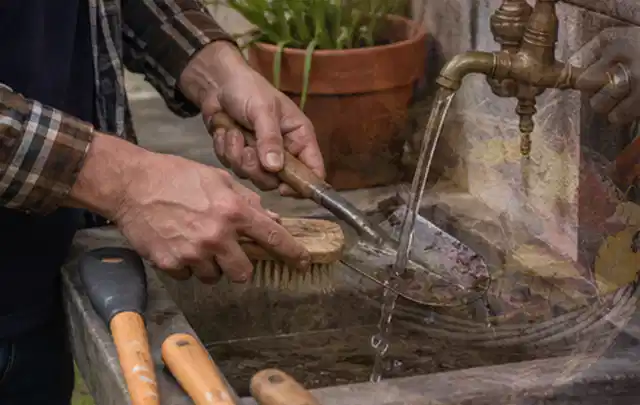 Hände reinigen gebrauchte Gartengeräte mit Bürste und Wasser am Außenbecken; Thema Ecovacs Goat, Schwerpunkt Kosten; Kontrolle.