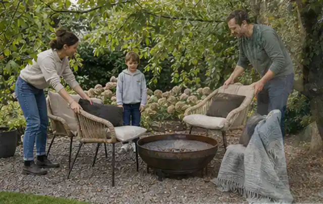 Familie stellt wetterfeste Sessel an einem geschützten Sitzplatz im Garten auf; Thema Einbaupools, Schwerpunkt Kosten; Kontrolle.