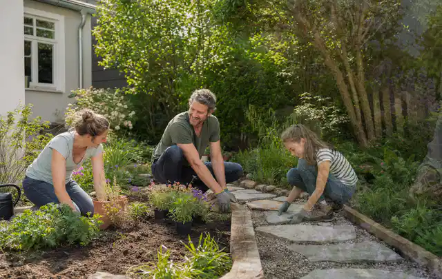 Familie geht auf einem Weg durch einen abwechslungsreich gestalteten Garten; Thema Familiengarten, Schwerpunkt Kosten; Umsetzung.