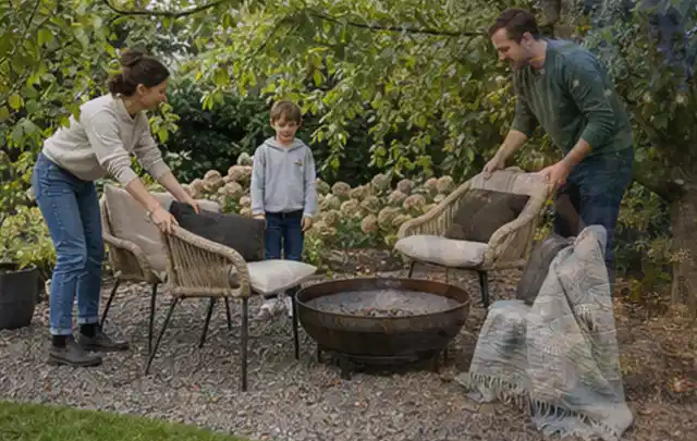 Familie stellt wetterfeste Sessel an einem geschützten Sitzplatz im Garten auf; Thema Familiengarten, Schwerpunkt Pflegeleichtigkeit; Ergebnis.