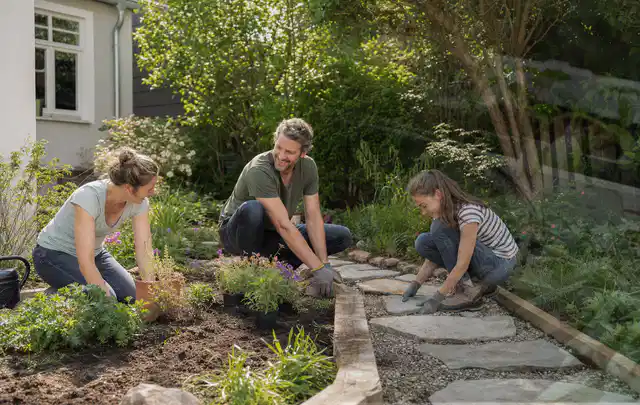Familie geht auf einem Weg durch einen abwechslungsreich gestalteten Garten; Thema Familiengarten, Schwerpunkt Wegeführung; Ergebnis.