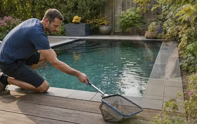 Person entfernt Blätter mit einem Kescher aus einem kleinen Gartenpool; Thema Feuerschalen, Schwerpunkt Outdoor Freizeit; Ausgangslage.