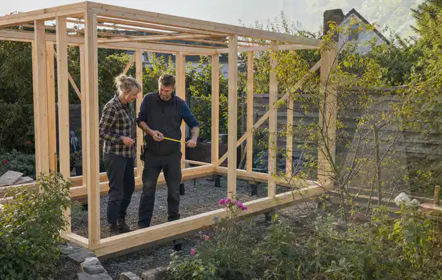 Person plant den Bau eines Gartenhauses auf einer vorbereiteten Fläche; Thema Fundamente, Schwerpunkt Gartenhäuser Bauen; Umsetzung.