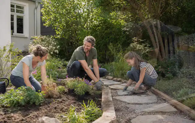 Familie geht auf einem Weg durch einen abwechslungsreich gestalteten Garten; Thema Gabionen, Schwerpunkt DIY; Kontrolle.