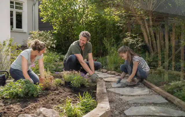 Familie geht auf einem Weg durch einen abwechslungsreich gestalteten Garten; Thema Gabionen, Schwerpunkt Fehlerhilfe; Kontrolle.