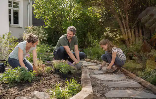 Familie geht auf einem Weg durch einen abwechslungsreich gestalteten Garten; Thema Gabionen, Schwerpunkt Materialwahl; Ausgangslage.