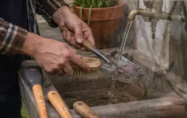 Hände reinigen gebrauchte Gartengeräte mit Bürste und Wasser am Außenbecken; Thema Gardena Sileno, Schwerpunkt Bestenliste; Ausgangslage.