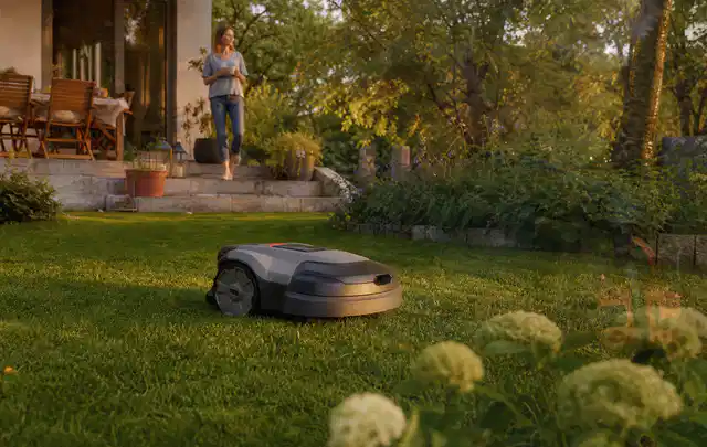 Mähroboter fährt am Abend über einen Rasen im Familiengarten; Thema Gardena Sileno, Schwerpunkt Fehlerhilfe; Praxisalltag.