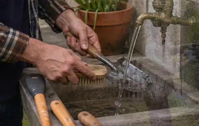Hände reinigen gebrauchte Gartengeräte mit Bürste und Wasser am Außenbecken; Thema Gardena Sileno, Schwerpunkt Kaufberatung; Ausgangslage.