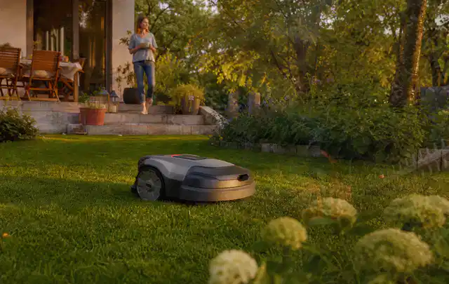 Mähroboter fährt am Abend über einen Rasen im Familiengarten; Thema Gardena Sileno, Schwerpunkt Sicherheit; Ausgangslage.