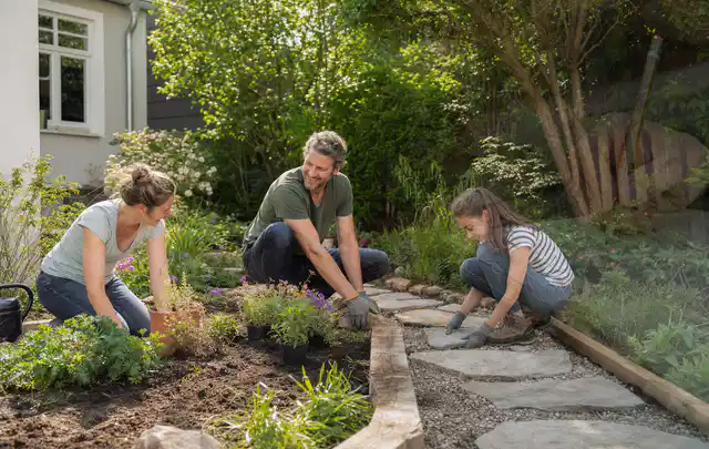 Familie geht auf einem Weg durch einen abwechslungsreich gestalteten Garten; Thema Garten am Neubau, Schwerpunkt Anleitung; Praxisalltag.