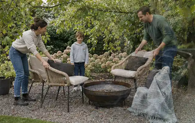 Familie stellt wetterfeste Sessel an einem geschützten Sitzplatz im Garten auf; Thema Garten am Neubau, Schwerpunkt Fehlerhilfe; Kontrolle.