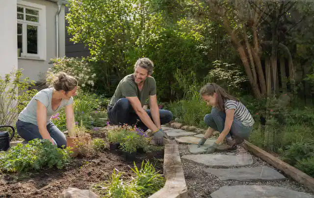 Familie geht auf einem Weg durch einen abwechslungsreich gestalteten Garten; Thema Garten am Neubau, Schwerpunkt Naturgarten; Kontrolle.