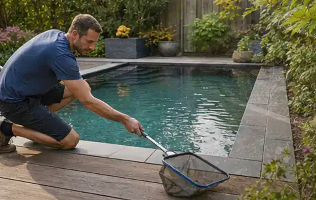 Person entfernt Blätter mit einem Kescher aus einem kleinen Gartenpool; Thema Gartenbeleuchtung, Schwerpunkt Ersatzteile; Umsetzung.