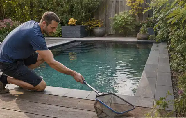 Person entfernt Blätter mit einem Kescher aus einem kleinen Gartenpool; Thema Gartenbeleuchtung, Schwerpunkt Outdoor Freizeit; Ausgangslage.