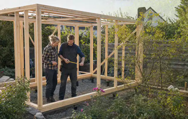 Person plant den Bau eines Gartenhauses auf einer vorbereiteten Fläche; Thema Gartenhäuser, Schwerpunkt Themenwelt; Ergebnis.