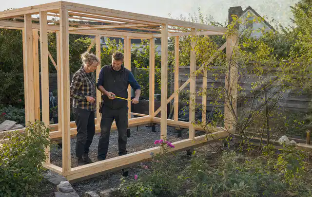 Person plant den Bau eines Gartenhauses auf einer vorbereiteten Fläche; Thema Gartenhaus Aufbau, Schwerpunkt Fehlerhilfe; Ergebnis.