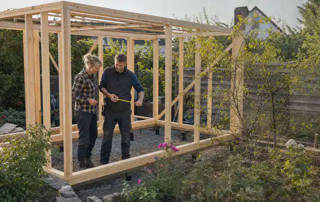 Person plant den Bau eines Gartenhauses auf einer vorbereiteten Fläche; Thema Gartenhaus Aufbau, Schwerpunkt Planung; Umsetzung.