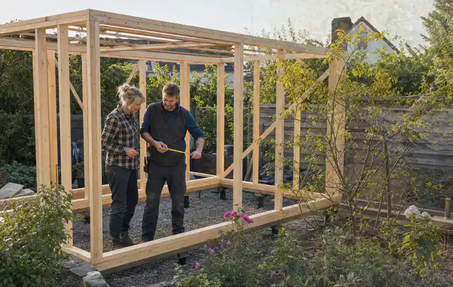 Person plant den Bau eines Gartenhauses auf einer vorbereiteten Fläche; Thema Gartenhaus aus Holz, Schwerpunkt Gärten mit kleiner Fläche; Praxisalltag.