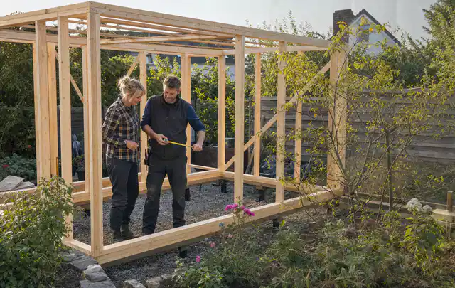 Person plant den Bau eines Gartenhauses auf einer vorbereiteten Fläche; Thema Gartenhaus aus Holz, Schwerpunkt Pflege; Ausgangslage.