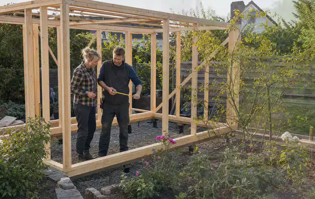 Person plant den Bau eines Gartenhauses auf einer vorbereiteten Fläche; Thema Gartenhaus aus Holz, Schwerpunkt Planung; Umsetzung.