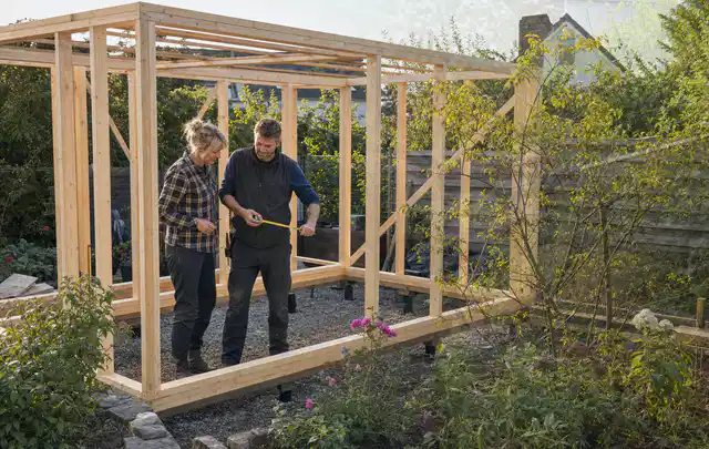 Person plant den Bau eines Gartenhauses auf einer vorbereiteten Fläche; Thema Gartenhaus aus Kunststoff, Schwerpunkt Aufbau; Ausgangslage.