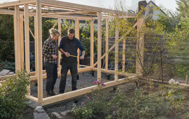 Person plant den Bau eines Gartenhauses auf einer vorbereiteten Fläche; Thema Gartenhaus aus Kunststoff, Schwerpunkt Baurecht; Kontrolle.