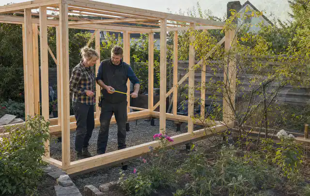 Person plant den Bau eines Gartenhauses auf einer vorbereiteten Fläche; Thema Gartenhaus aus Kunststoff, Schwerpunkt Checkliste; Kontrolle.