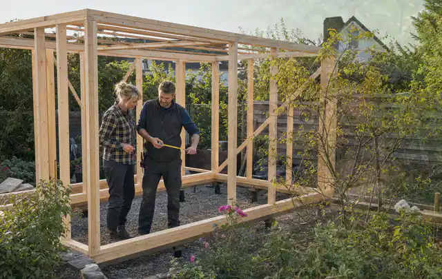 Person plant den Bau eines Gartenhauses auf einer vorbereiteten Fläche; Thema Gartenhaus aus Kunststoff, Schwerpunkt DIY; Ergebnis.