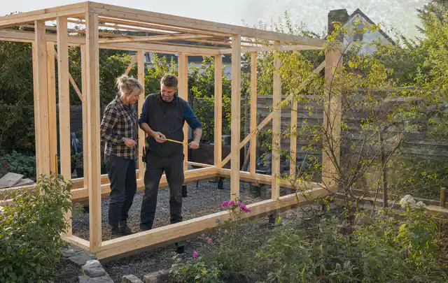 Person plant den Bau eines Gartenhauses auf einer vorbereiteten Fläche; Thema Gartenhaus aus Kunststoff, Schwerpunkt Fundament; Umsetzung.
