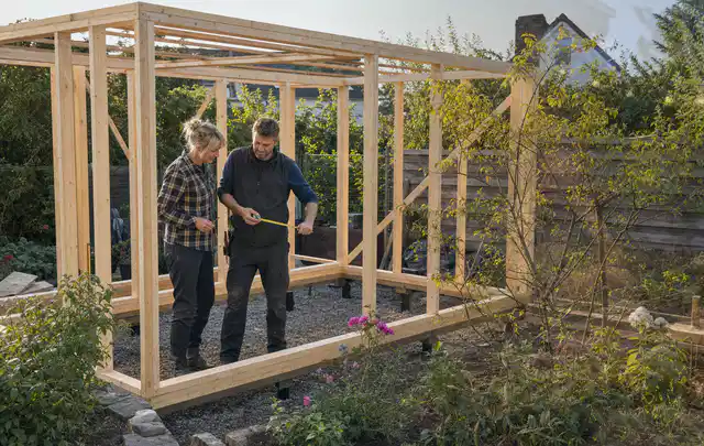Person plant den Bau eines Gartenhauses auf einer vorbereiteten Fläche; Thema Gartenhaus aus Kunststoff, Schwerpunkt Gärten mit kleiner Fläche; Ergebnis.