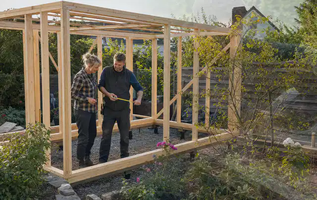 Person plant den Bau eines Gartenhauses auf einer vorbereiteten Fläche; Thema Gartenhaus aus Kunststoff, Schwerpunkt Gestaltung; Umsetzung.