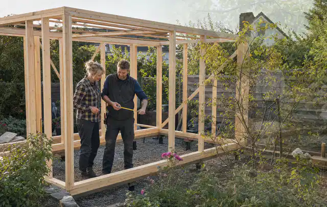 Person plant den Bau eines Gartenhauses auf einer vorbereiteten Fläche; Thema Gartenhaus aus Kunststoff, Schwerpunkt Kosten; Ausgangslage.