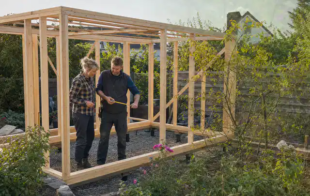 Person plant den Bau eines Gartenhauses auf einer vorbereiteten Fläche; Thema Gartenhaus aus Kunststoff, Schwerpunkt Pflege; Kontrolle.