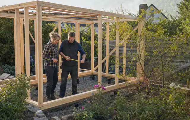 Person plant den Bau eines Gartenhauses auf einer vorbereiteten Fläche; Thema Gartenhaus aus Kunststoff, Schwerpunkt Standort; Umsetzung.