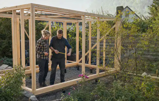 Person plant den Bau eines Gartenhauses auf einer vorbereiteten Fläche; Thema Gartenhaus aus Metall, Schwerpunkt Aufbau; Ergebnis.