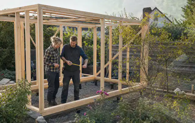 Person plant den Bau eines Gartenhauses auf einer vorbereiteten Fläche; Thema Gartenhaus aus Metall, Schwerpunkt Dimensionierung; Umsetzung.