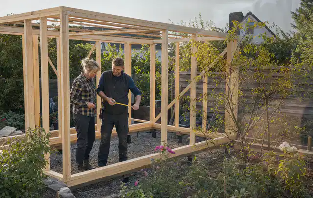 Person plant den Bau eines Gartenhauses auf einer vorbereiteten Fläche; Thema Gartenhaus aus Metall, Schwerpunkt Fehlerhilfe; Kontrolle.