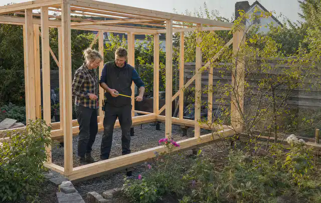 Person plant den Bau eines Gartenhauses auf einer vorbereiteten Fläche; Thema Gartenhaus aus Metall, Schwerpunkt Gärten mit kleiner Fläche; Ausgangslage.